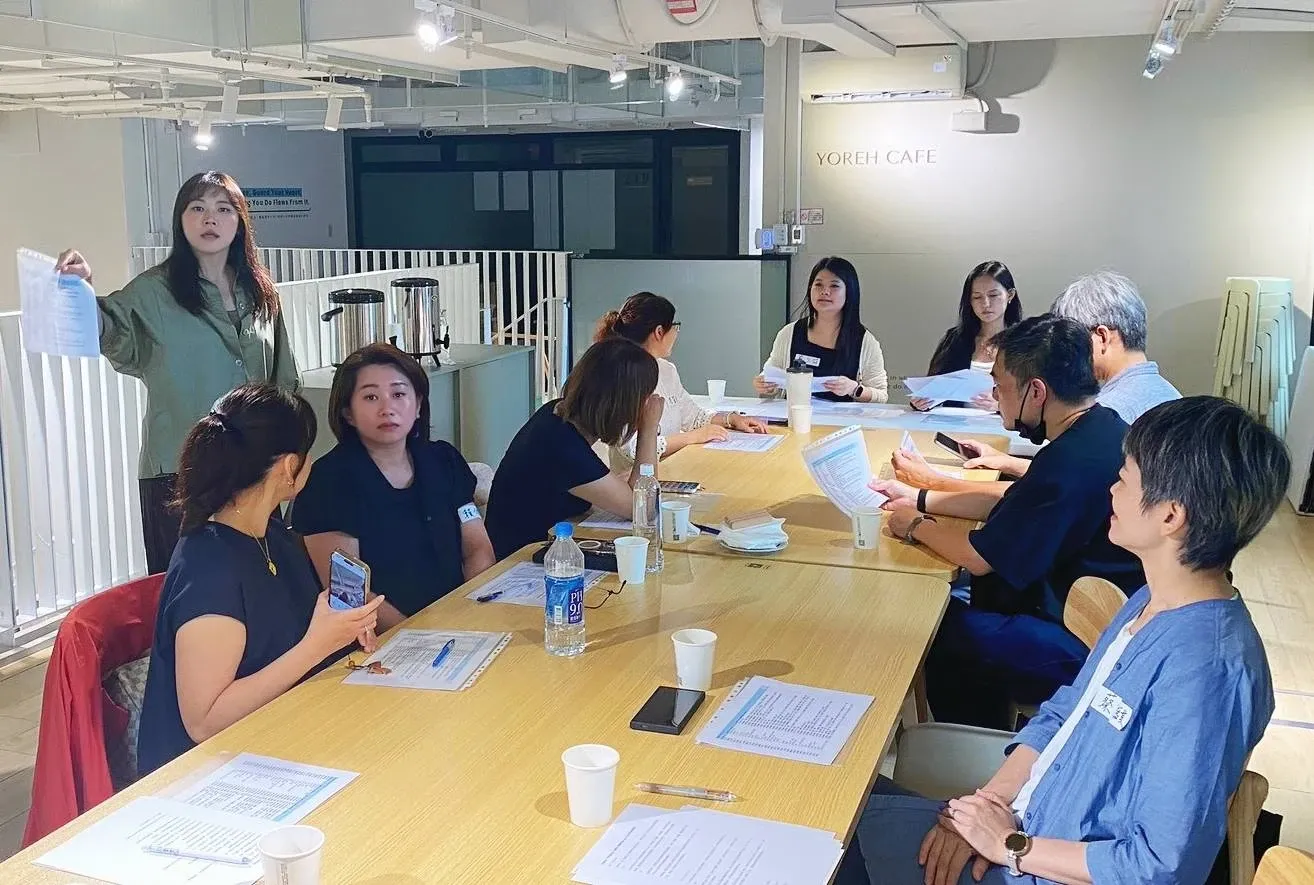 與會者手持資料發言